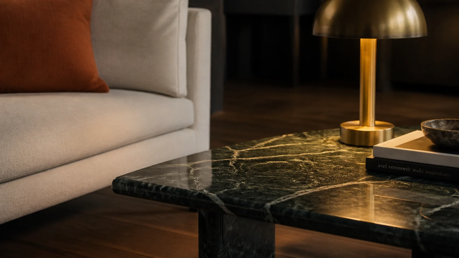 deep green veined marble top glowing beside a pale linen sofa