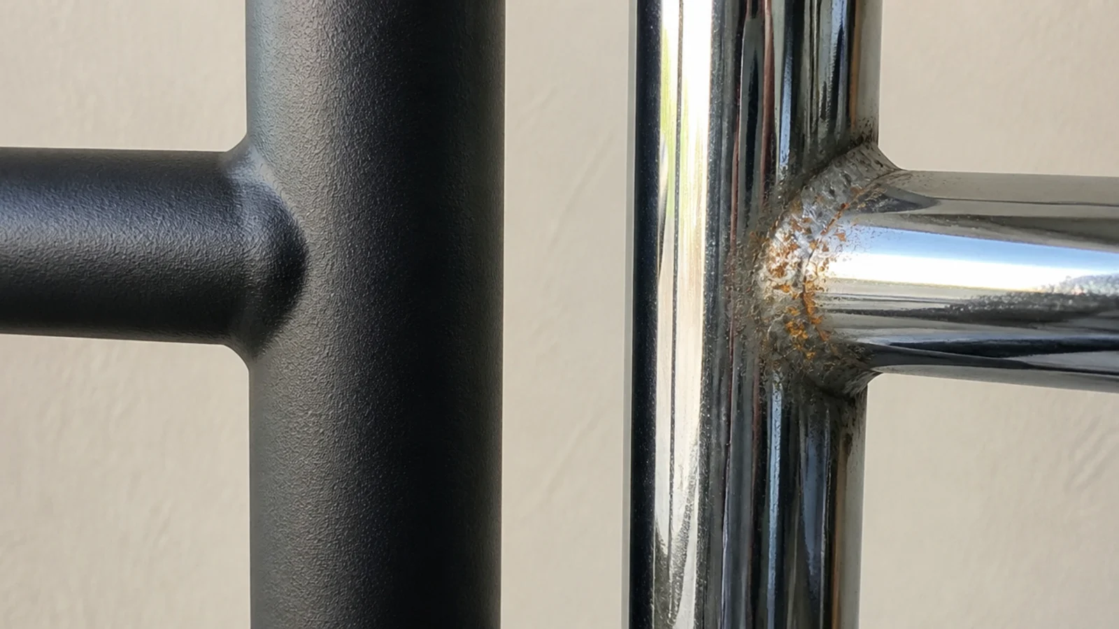 matte black powder coated cart frame beside a chipped chrome one