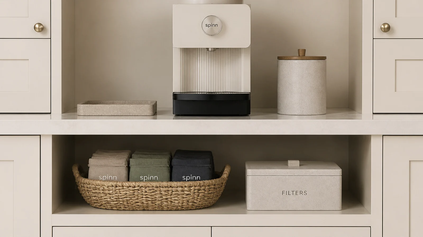 basket and box containing spare coffee supplies beneath a tidy counter