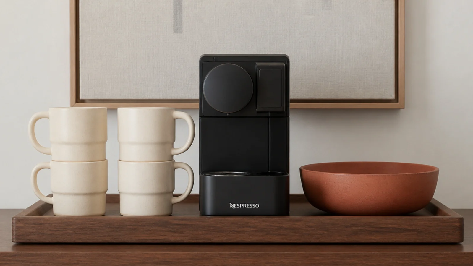 matching stoneware mugs stacked neatly beside a small coffee machine