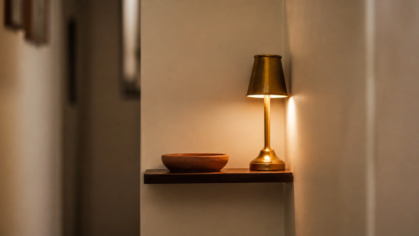 slim shelf fitted into a narrow hallway nook holding a lamp