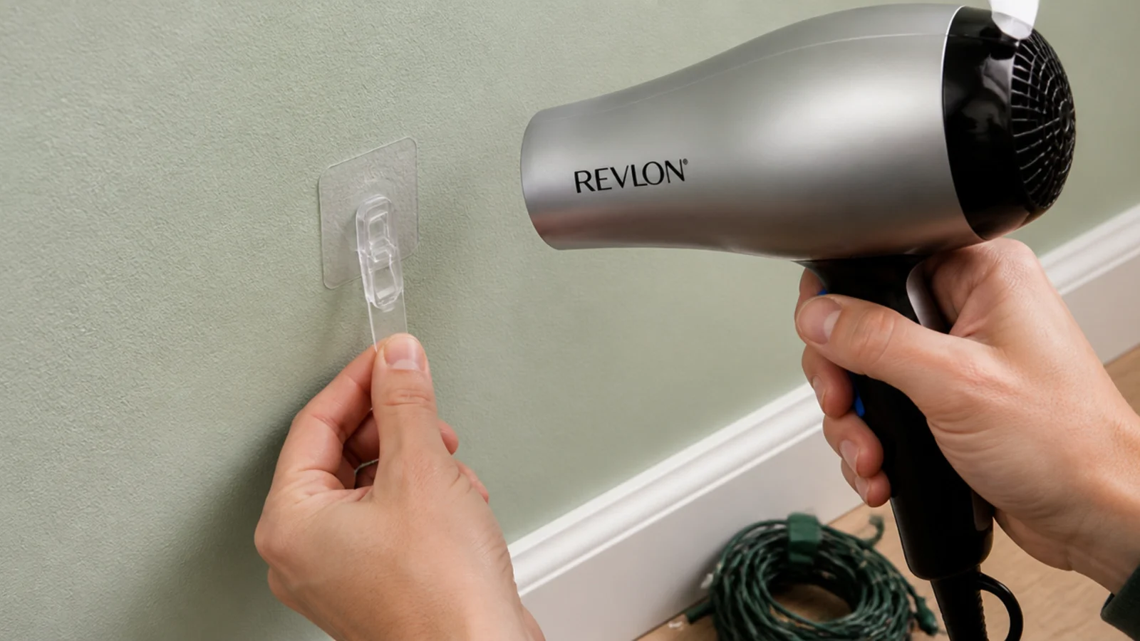 hairdryer warming an adhesive clip on a bedroom wall