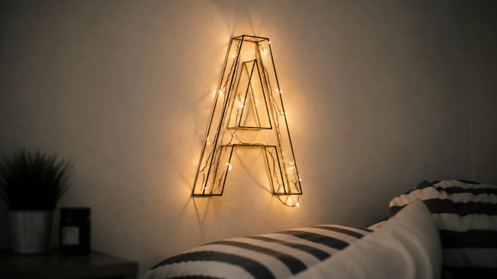 wire frame letter shape wound with warm micro lights on a wall