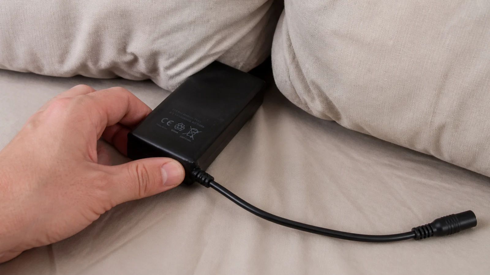 battery pack pulled out from between two bed cushions
