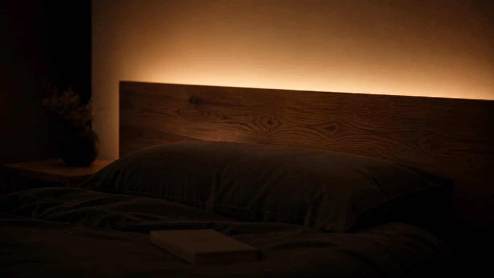 glow rising from behind a solid headboard with no bulbs visible