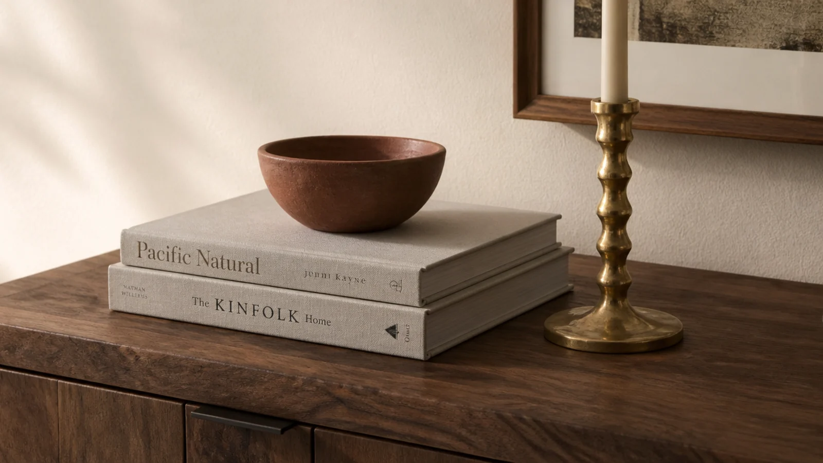 small clay bowl raised on two stacked books on an entry console