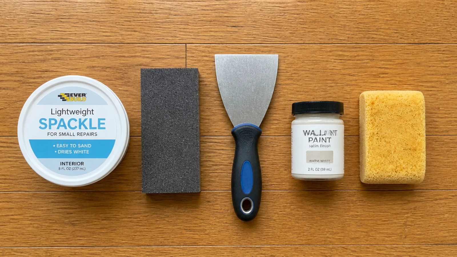 spackle sanding block and paint sample laid out for entryway wall repairs