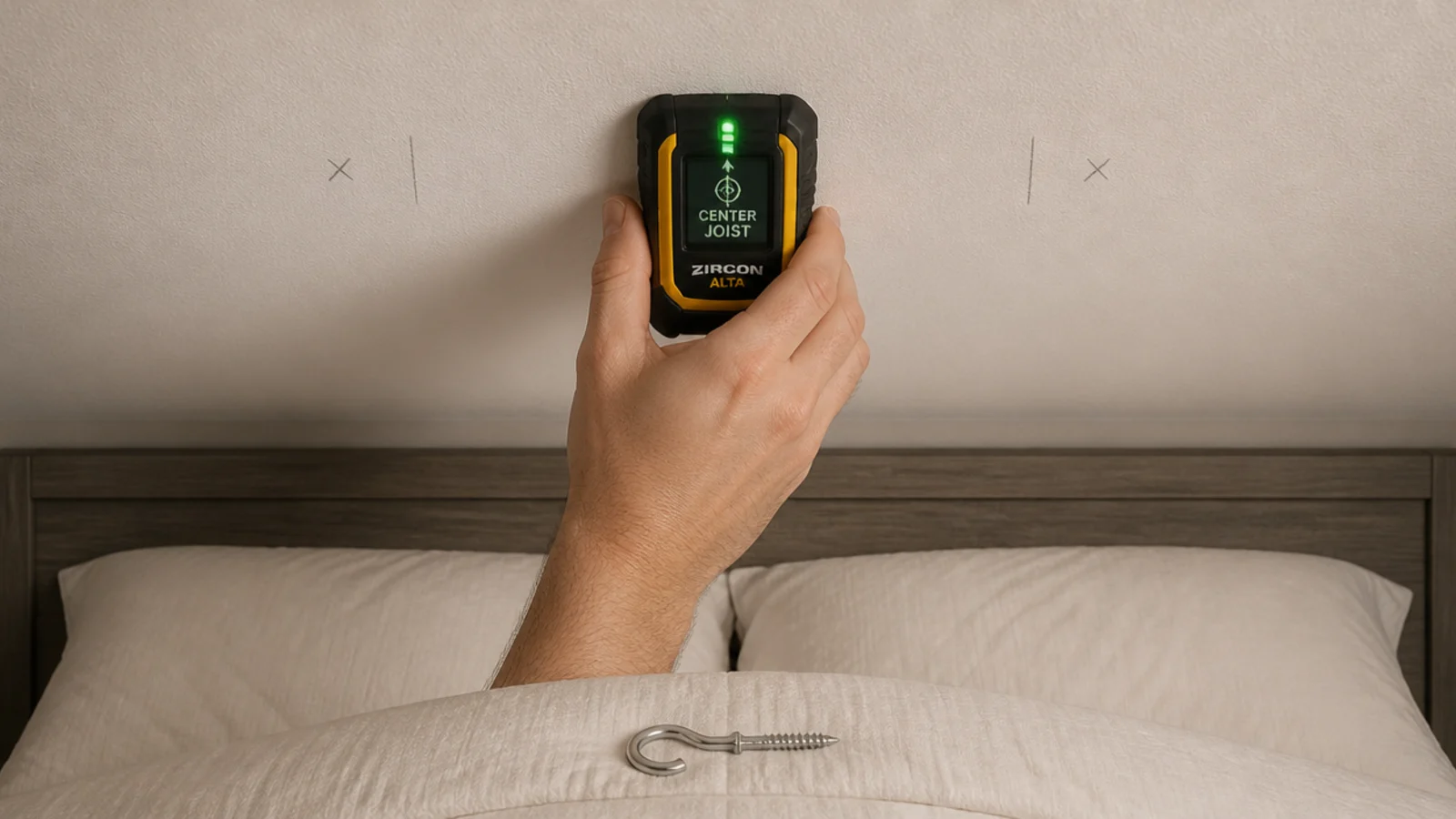 stud finder held against a bedroom ceiling above a bed