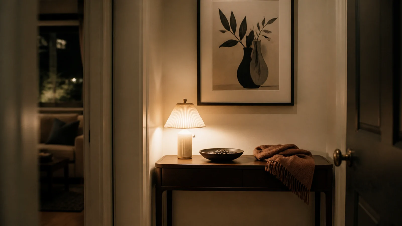 small shade lighting a shallow console in a narrow hall