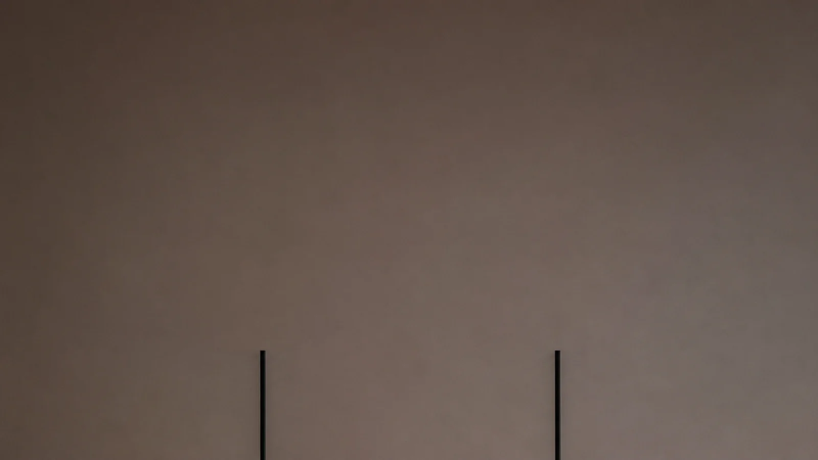 tall view of modern hanging lights glowing over a pale stone counter