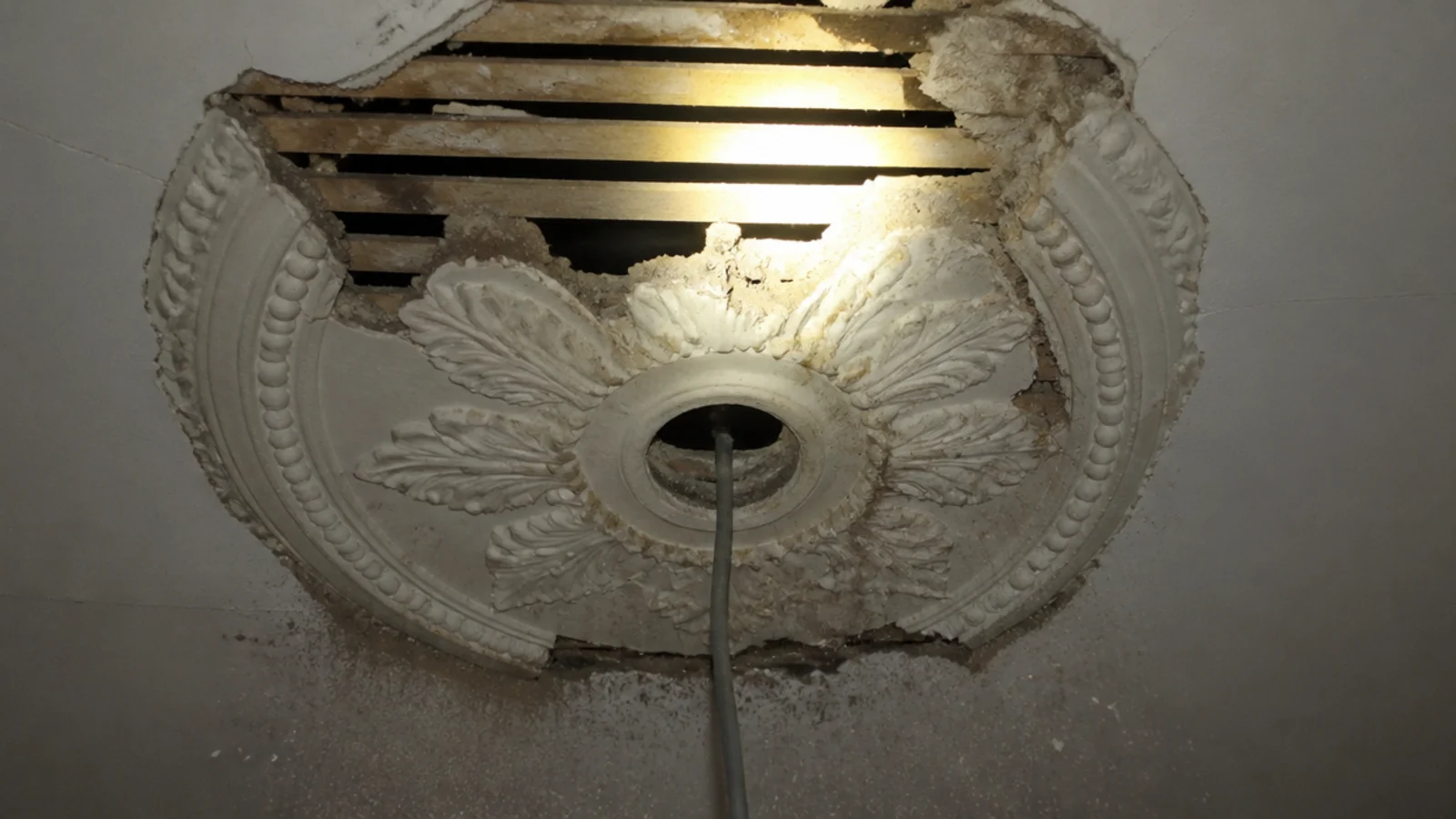 old plaster rose removed showing the fixing point behind it