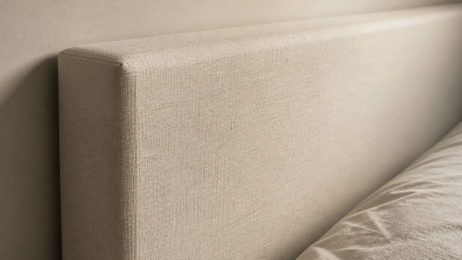 foam edges showing sharply through the linen of a headboard panel