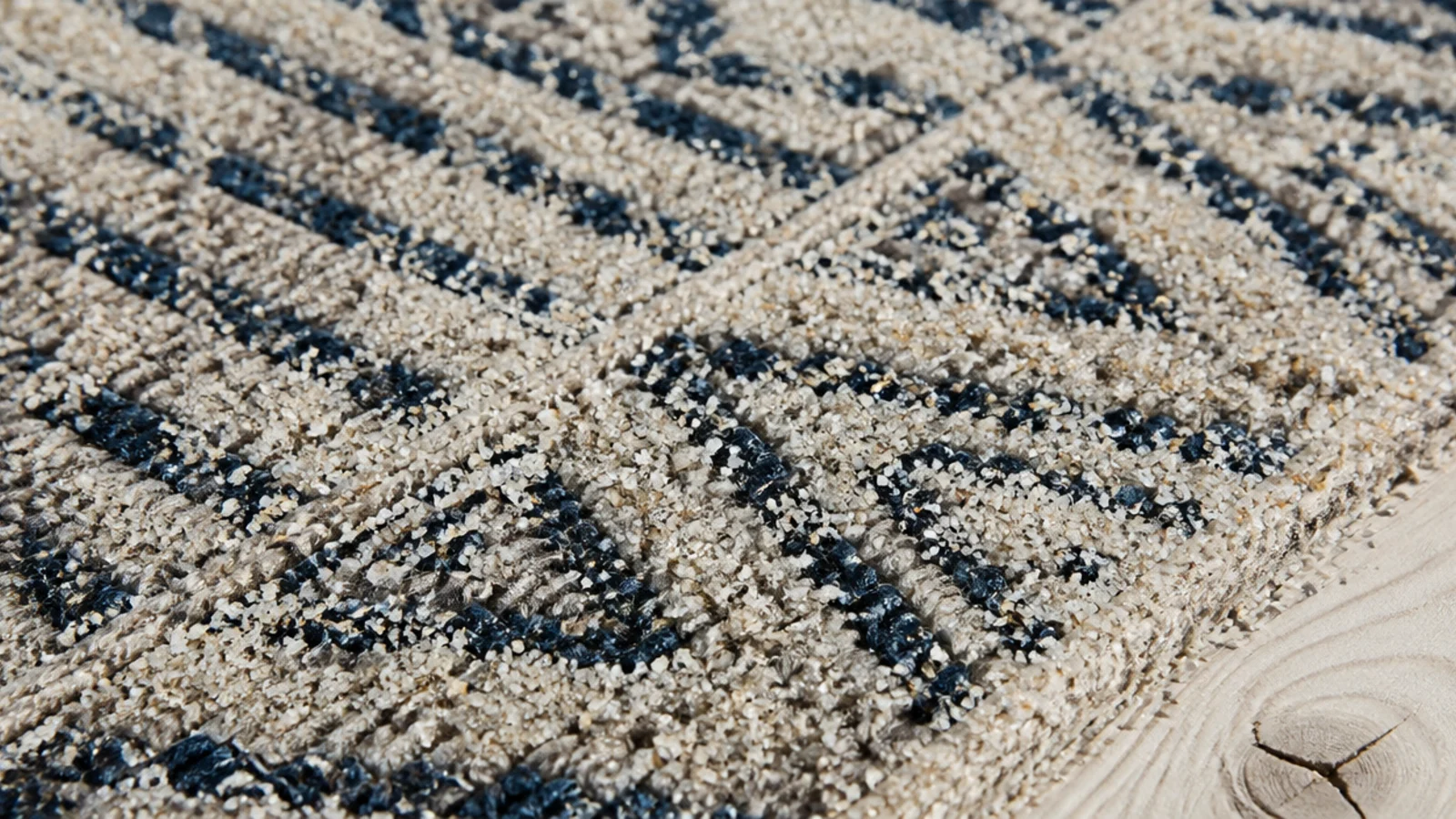 fine sand sitting on the surface of a very low pile rug