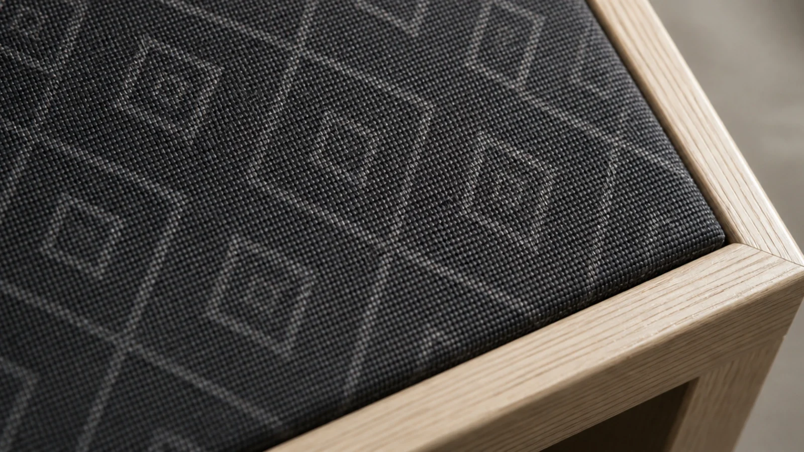 faint tonal pattern woven across a deep charcoal rug surface