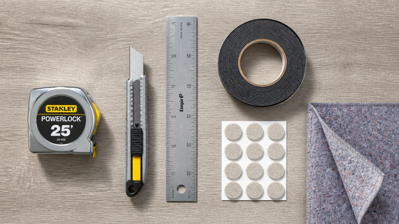 tools and materials for a rug layering job laid out on boards