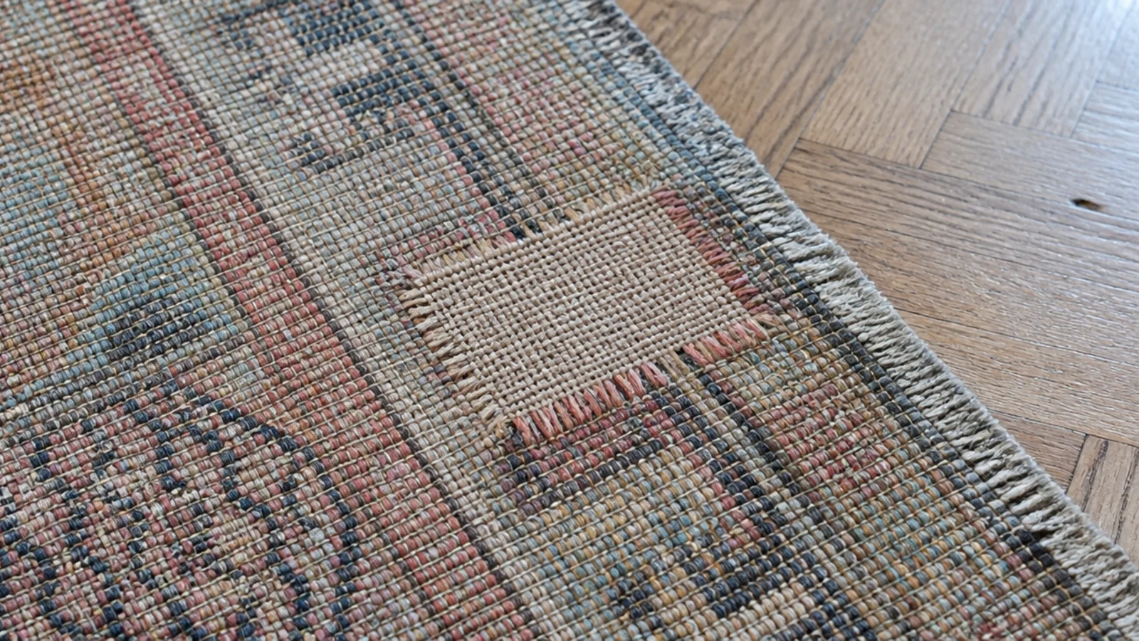 small reweave patch visible from the back of an old wool rug