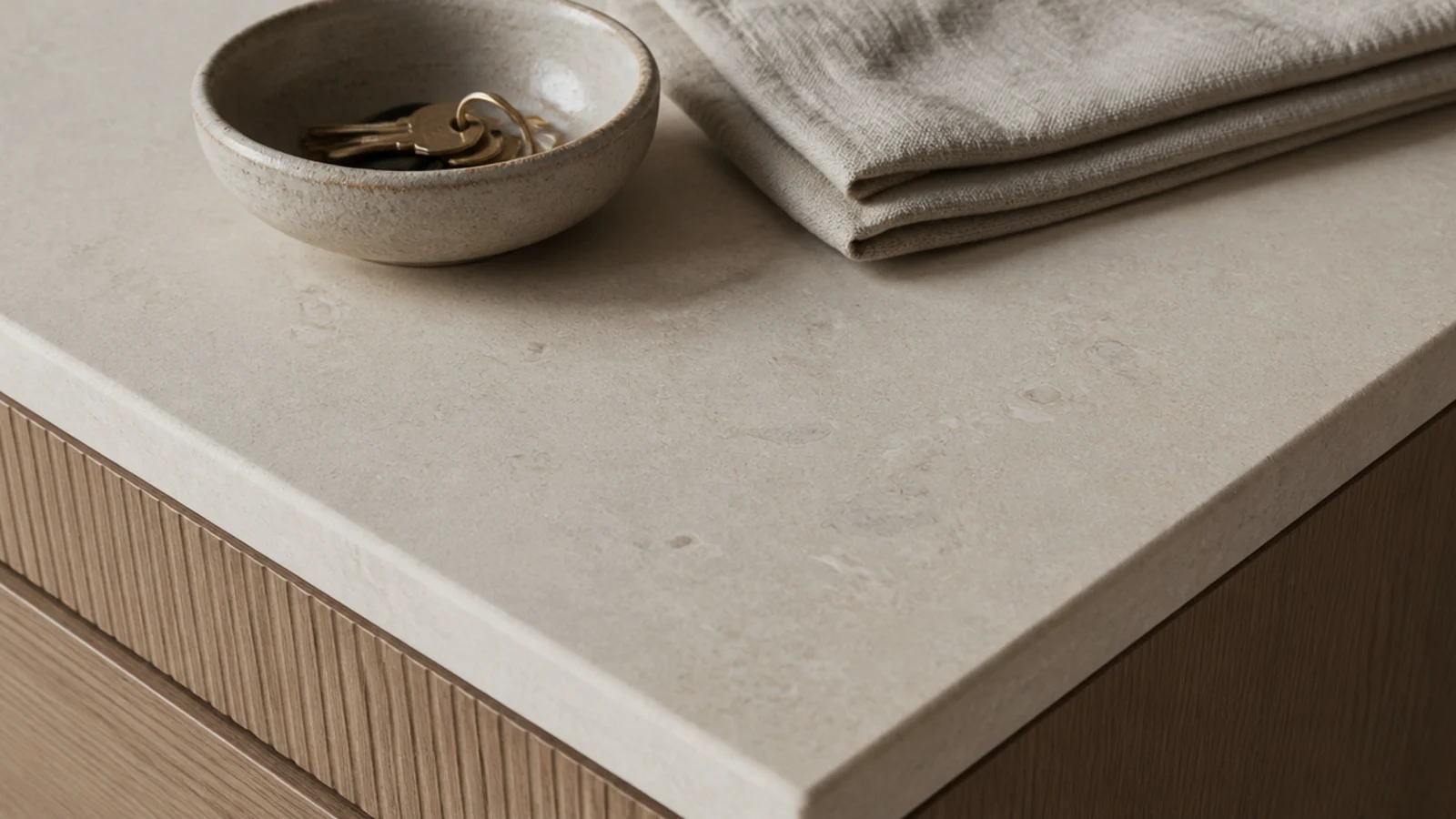 honed stone top on a modern shoe cabinet holding a stoneware key bowl