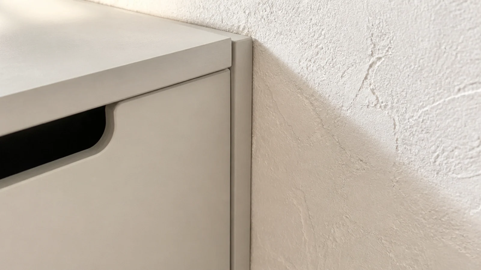 scribe trim closing the tapering gap beside a hallway shoe cabinet