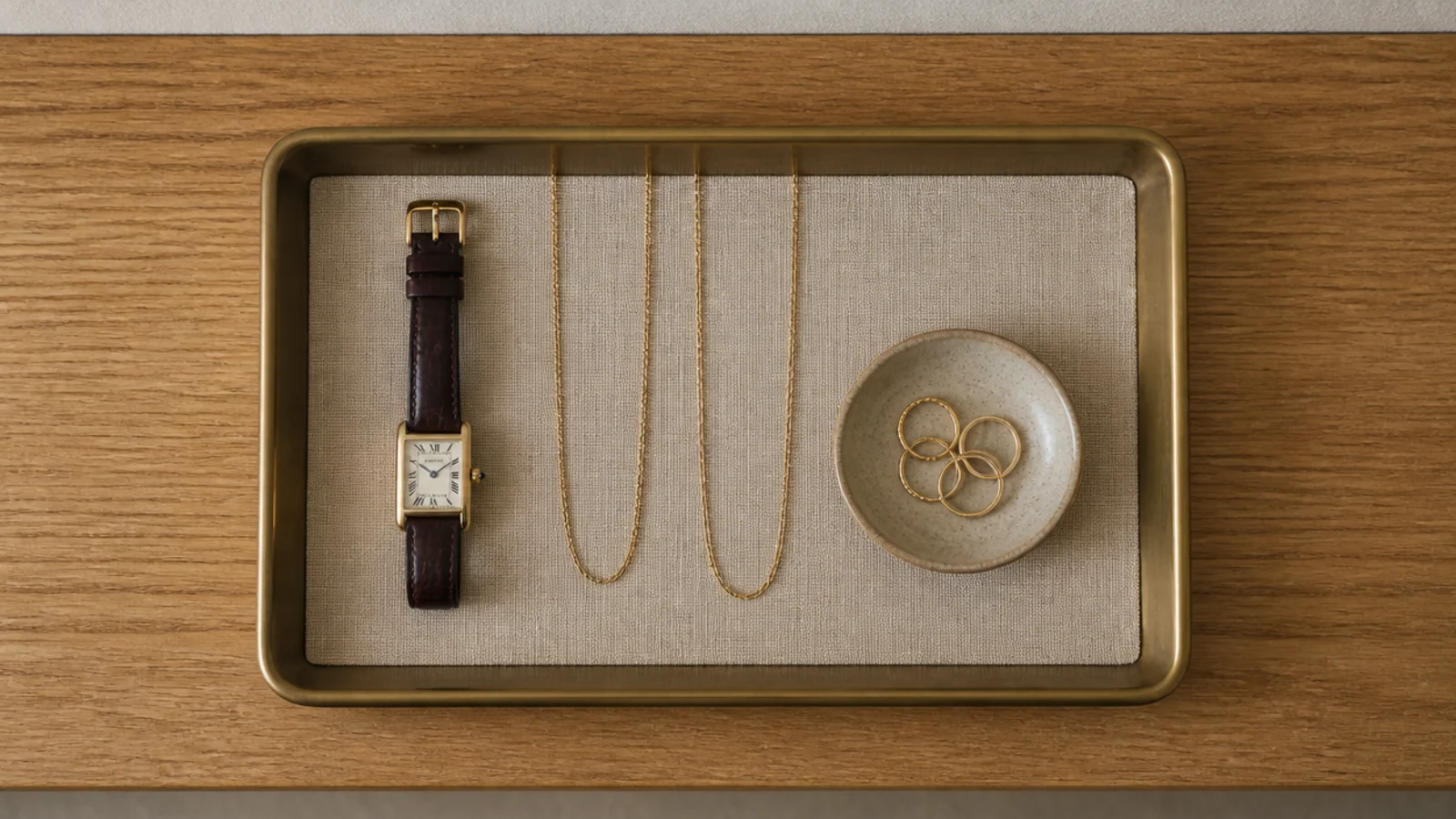 single linen lined tray holding jewelry on a minimalist closet shelf