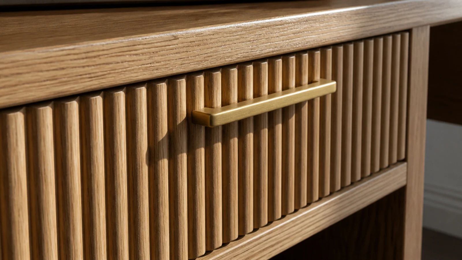 fluted wooden drawer front under a desk with slim brass pull