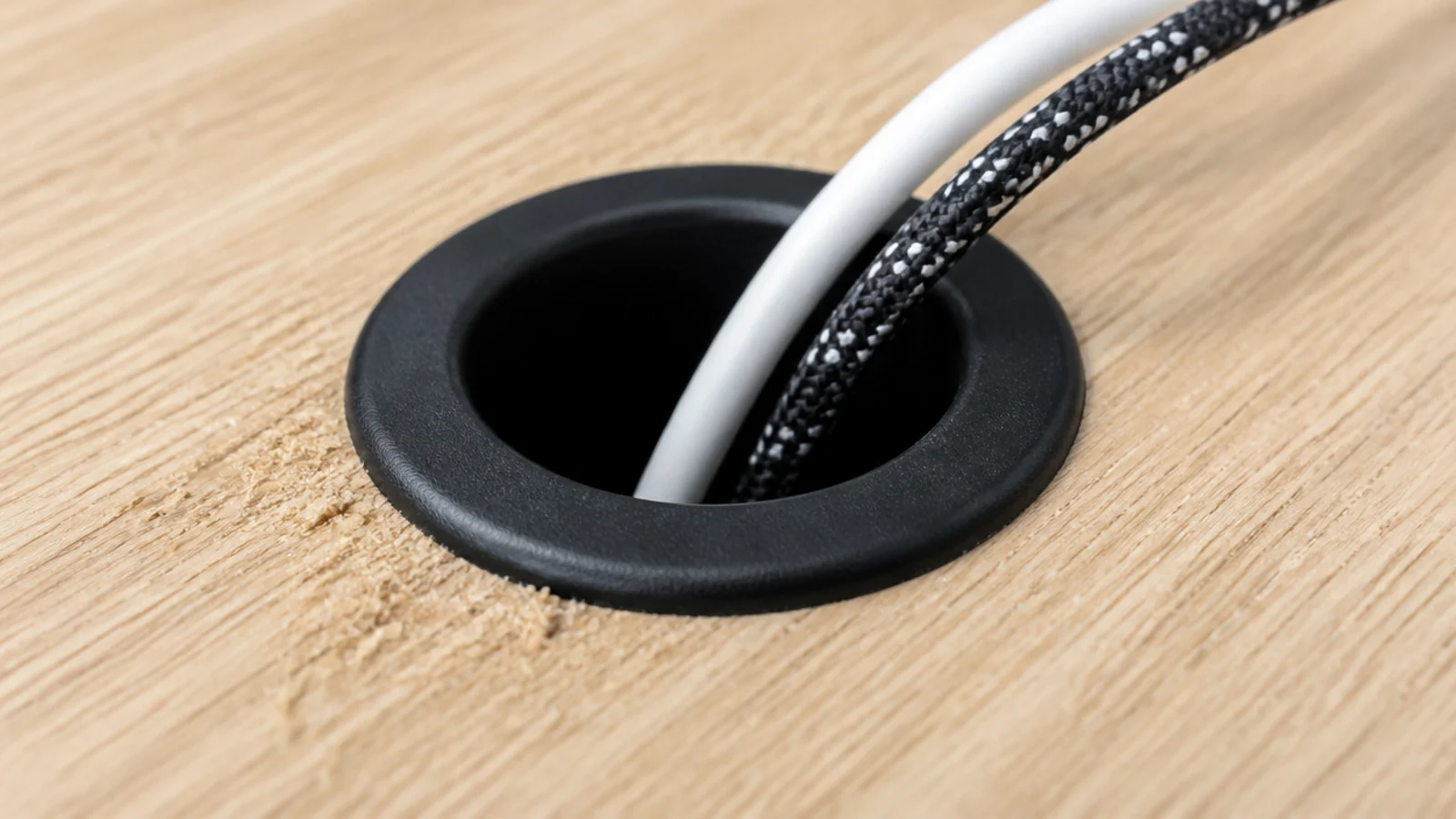 black grommet ring seated in a drilled hole on a desk top