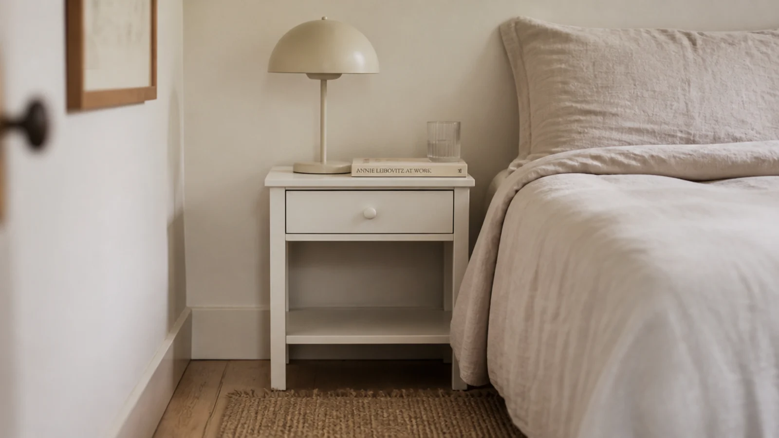 small desk placed beside a bed serving as a nightstand too