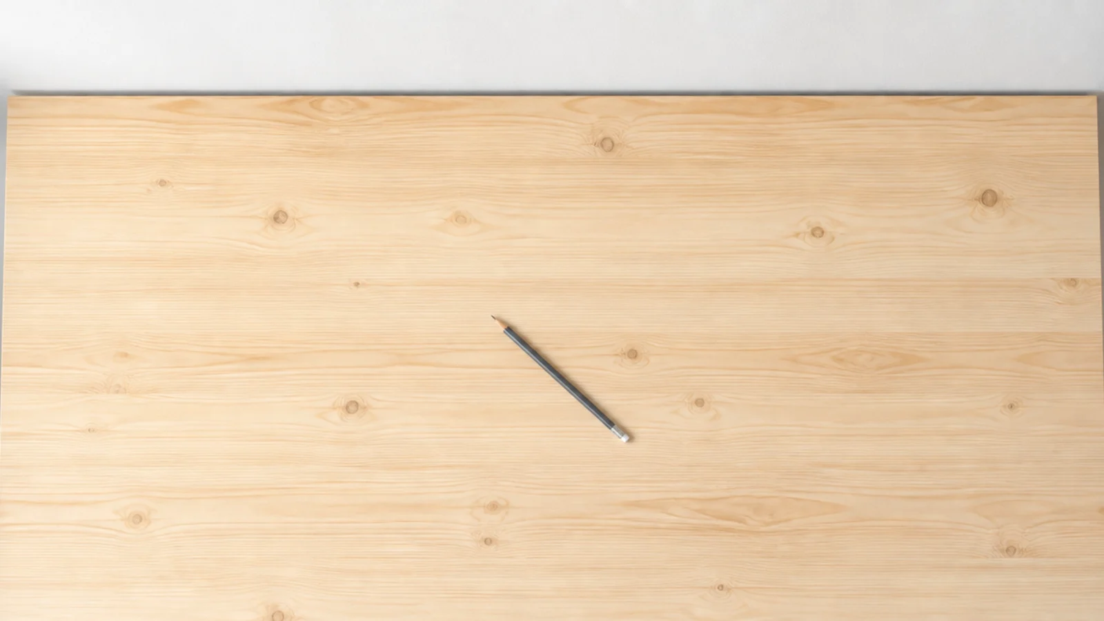 completely bare desk surface with a single pencil lying across