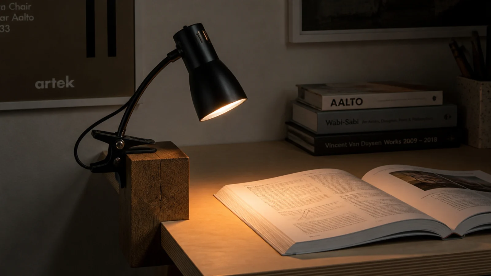 clip lamp clamped to a solid wood block raising it above books