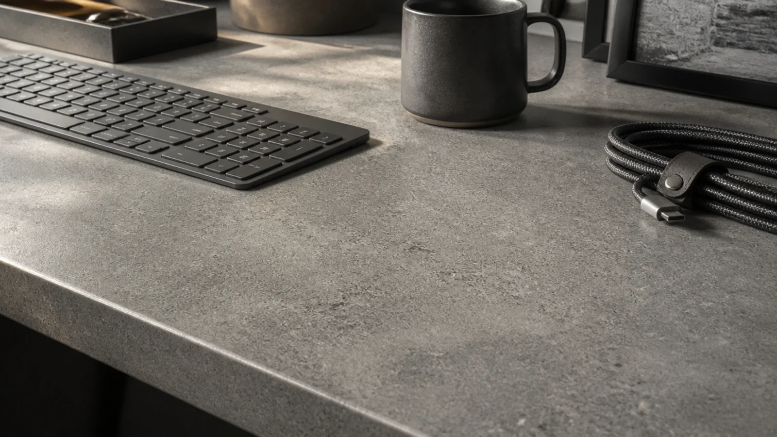 grey concrete effect laminate desk surface with a keyboard and mug