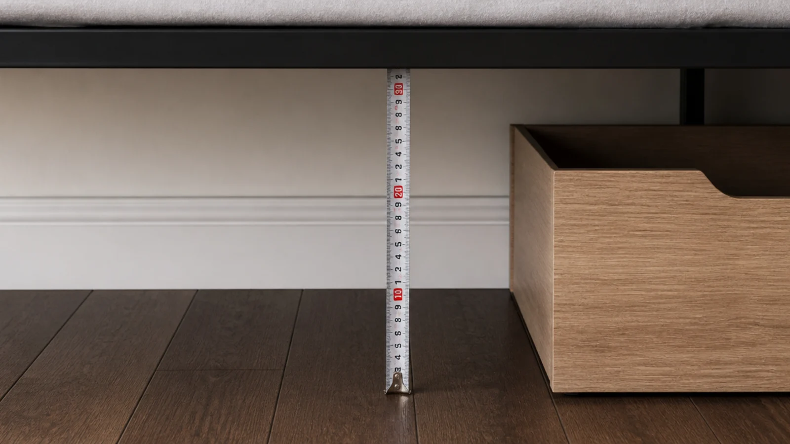 tape measuring from floor to the underside of a bed frame