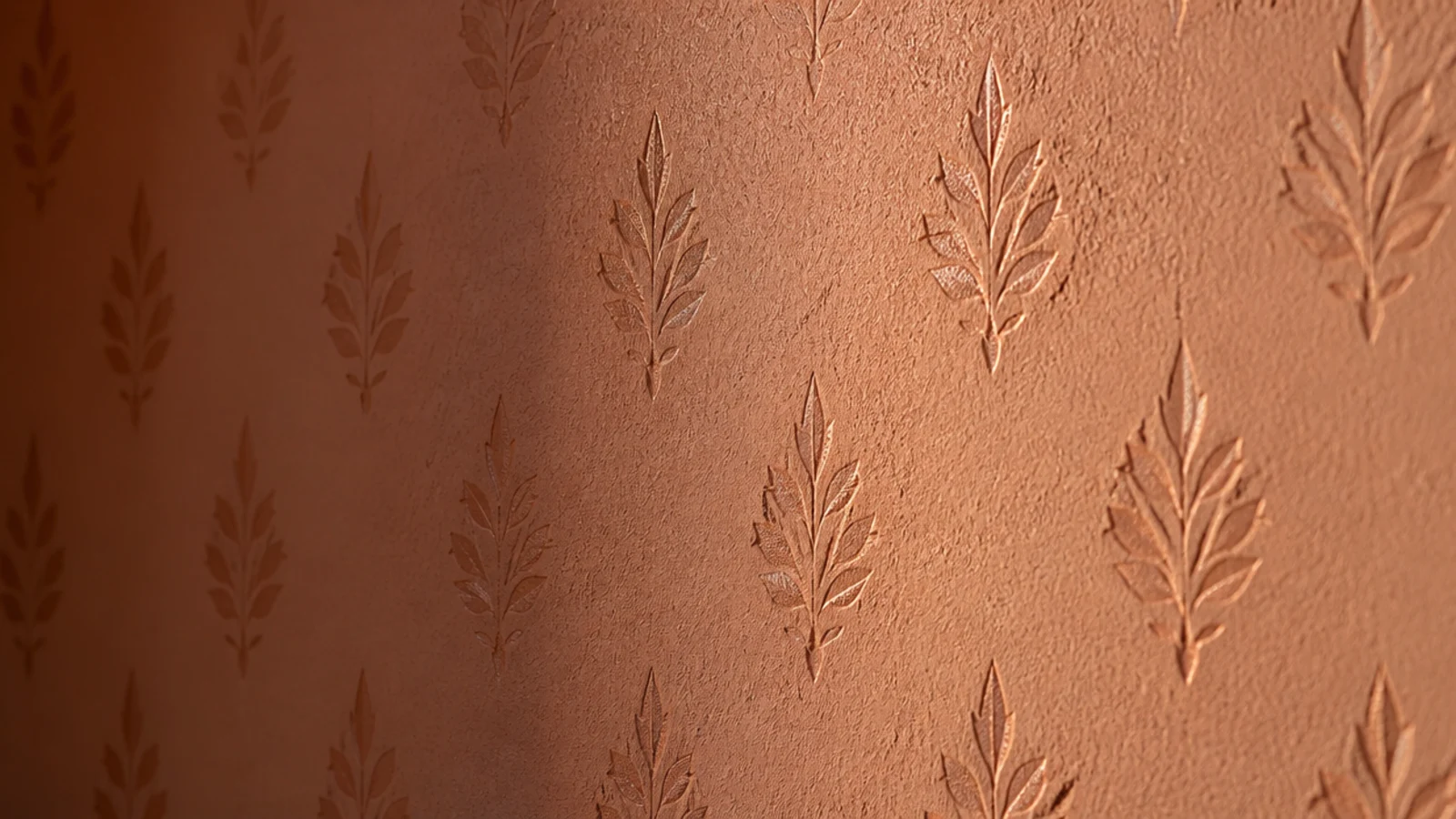 small stencilled motif repeating across a wall in a deeper tone