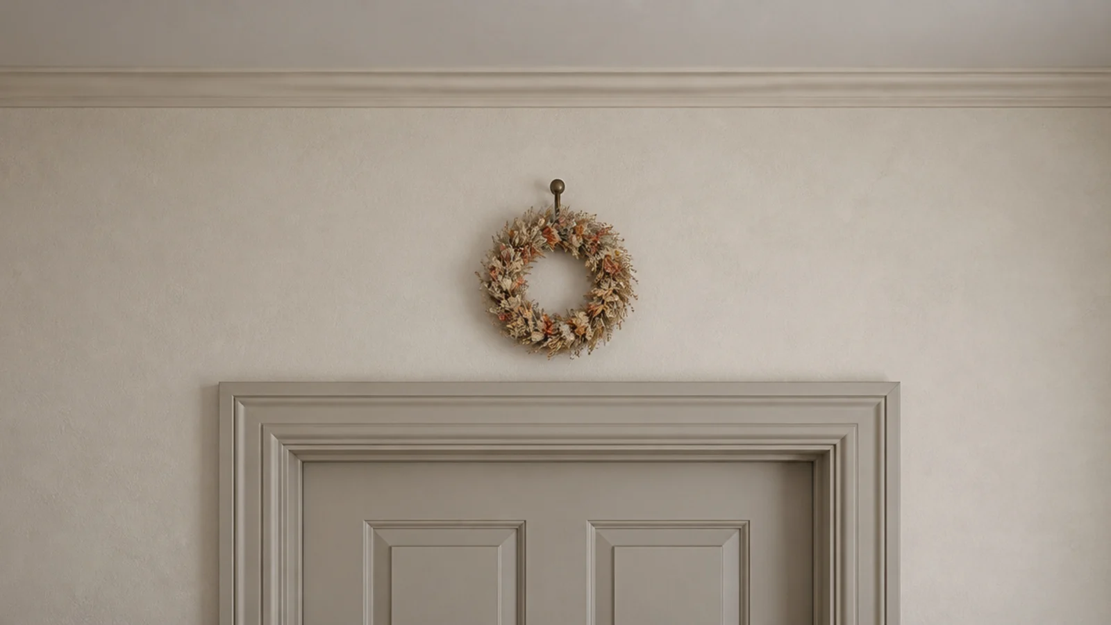 small dried flower wreath hanging high above a bedroom doorway