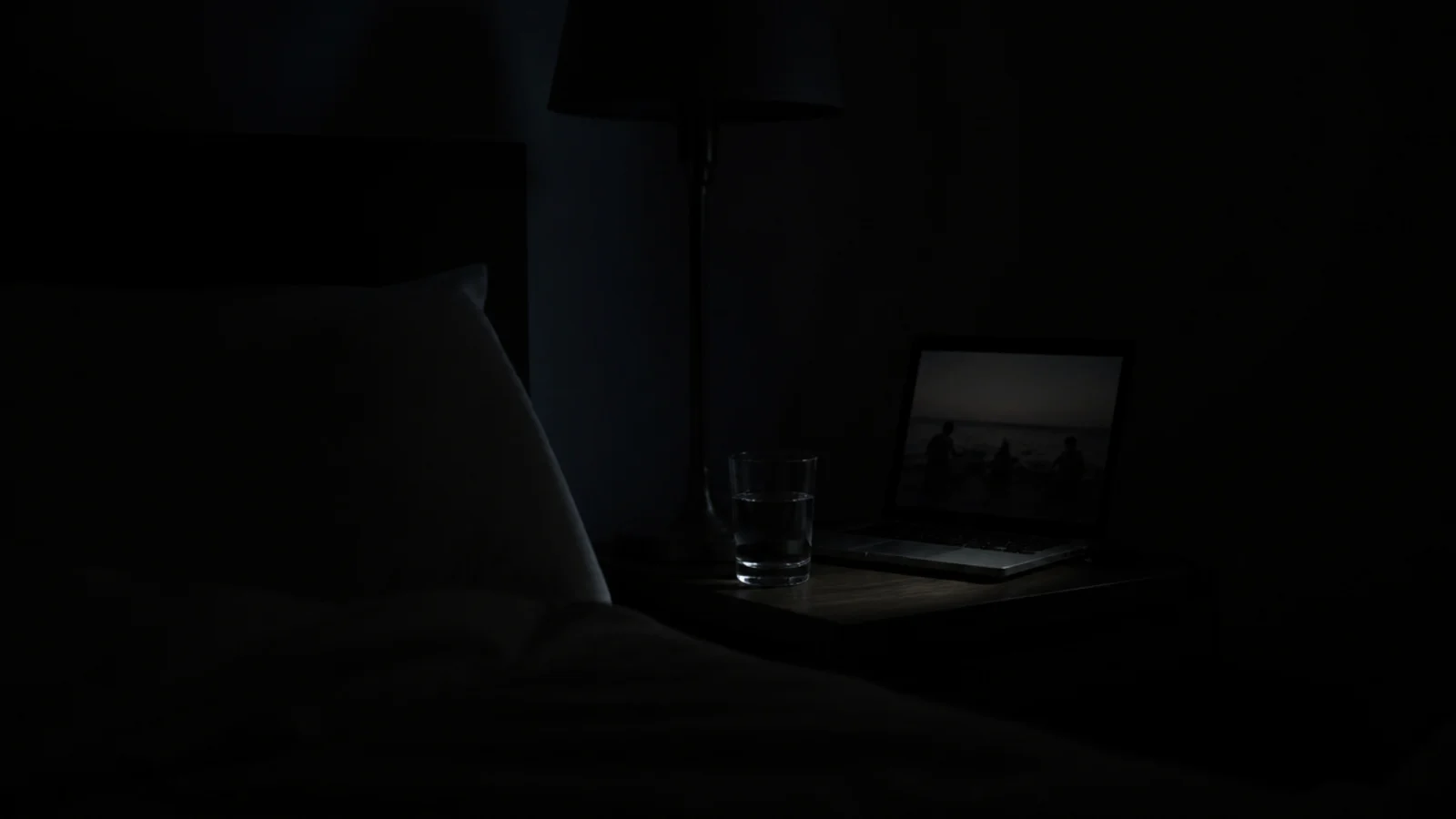 dimmed screen glowing softly in a dark bedroom late at night