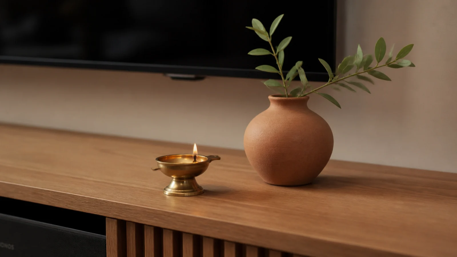 brass lamp and terracotta pot styled on a wooden media ledge