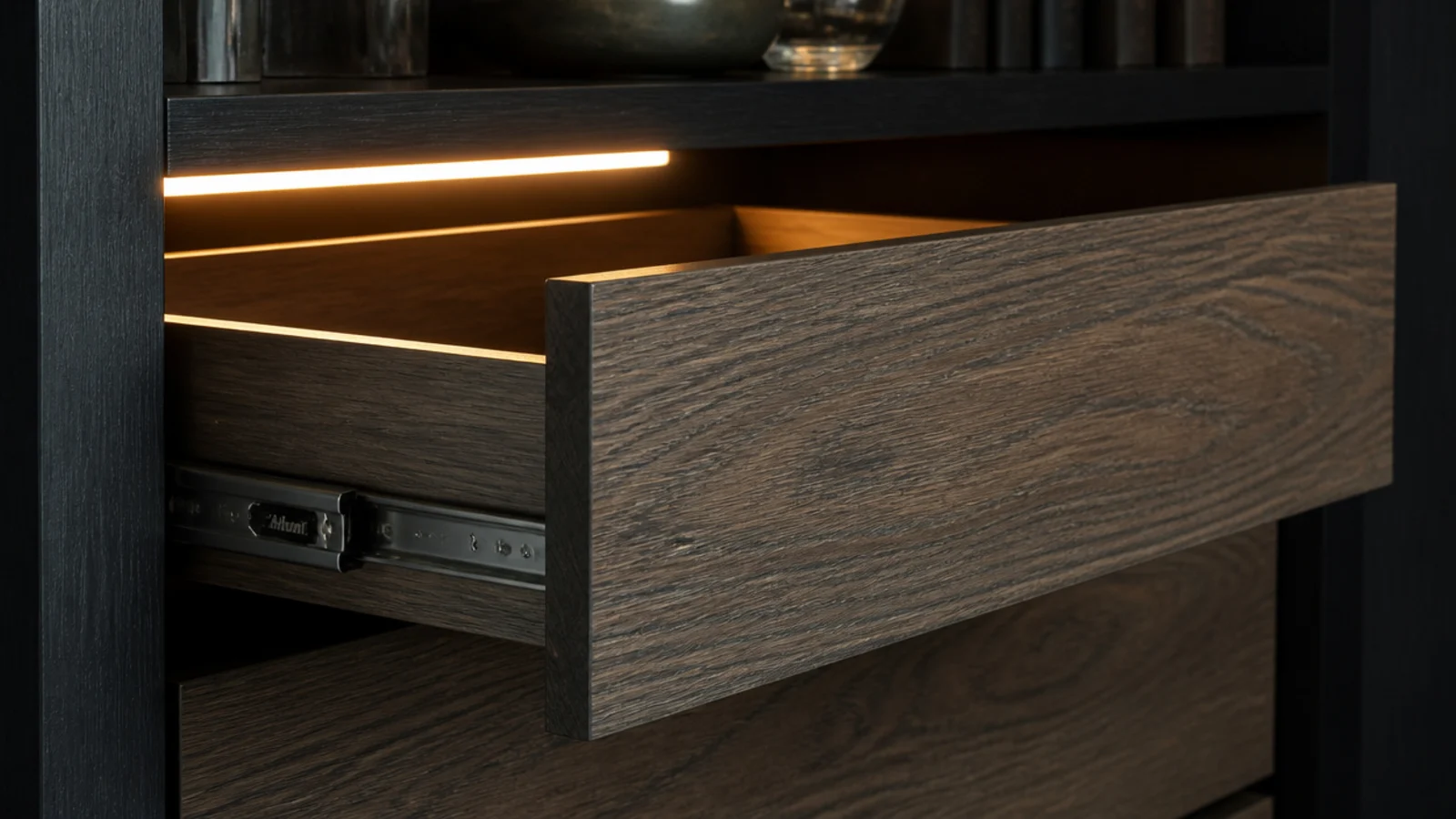 drawer front easing closed on soft close runners in a dark cabinet