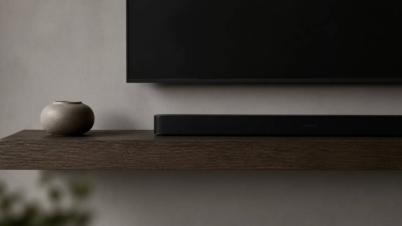 one long floating shelf under a screen with two objects on it