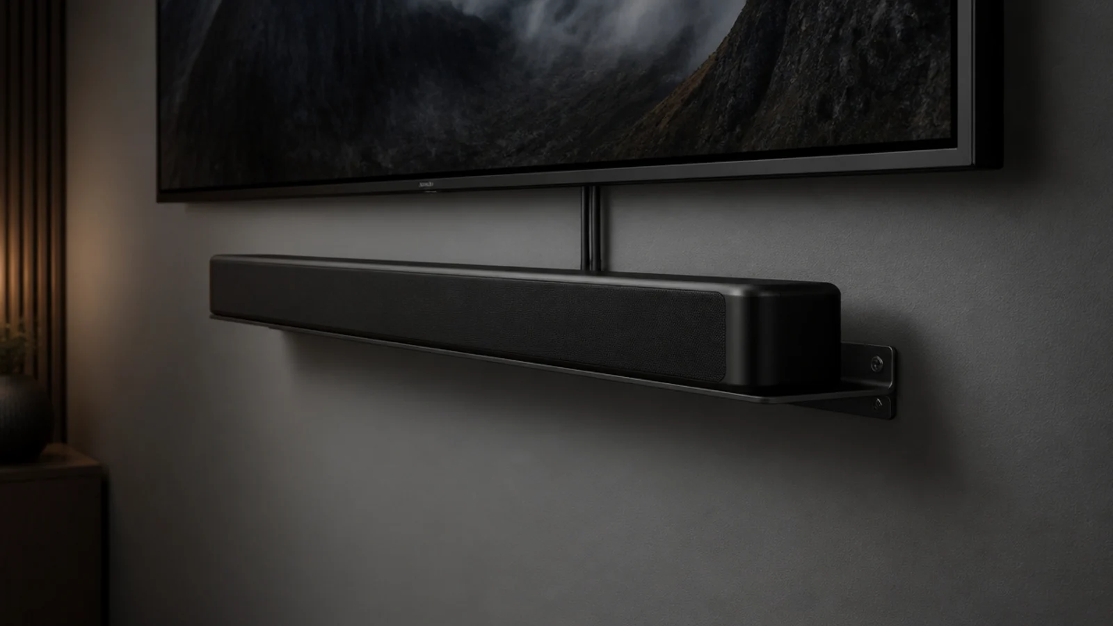 soundbar hanging on a bracket directly below a wall mounted screen