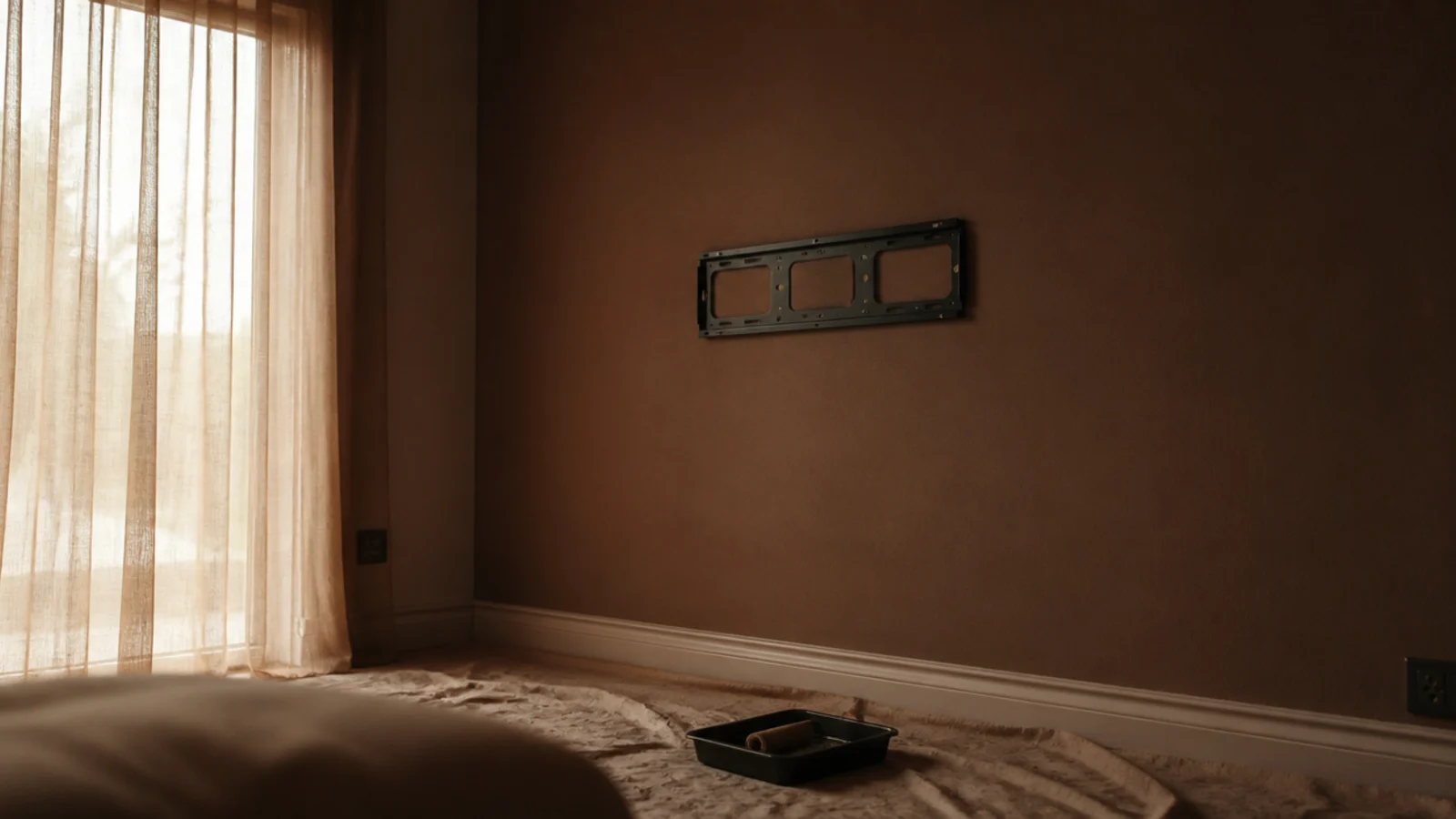 freshly painted deep clay feature wall drying behind a bare screen mount
