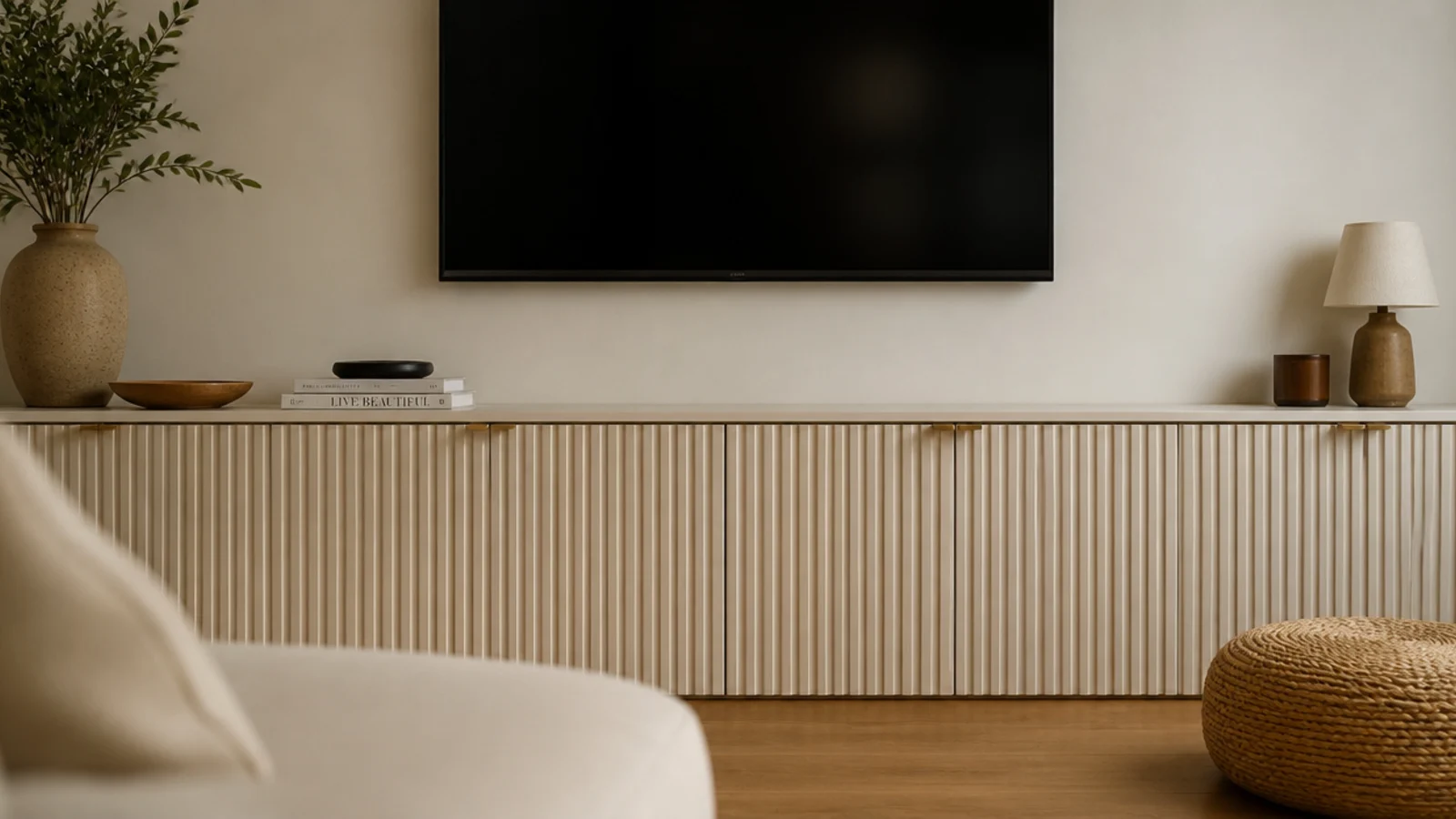 fluted cabinet doors below a plain painted wall and mounted screen