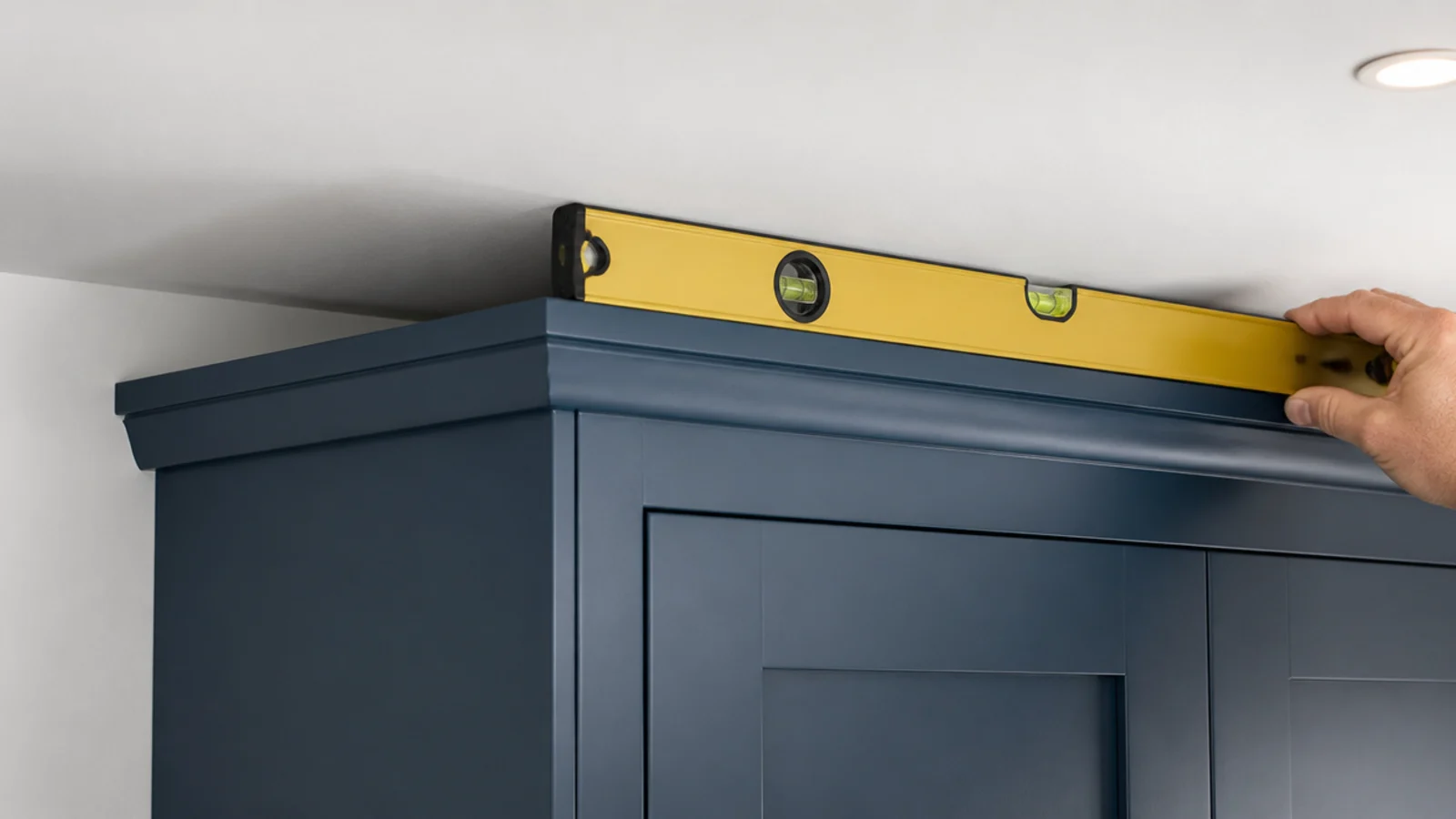 narrow shadow gap left between a tall cabinet and the ceiling above