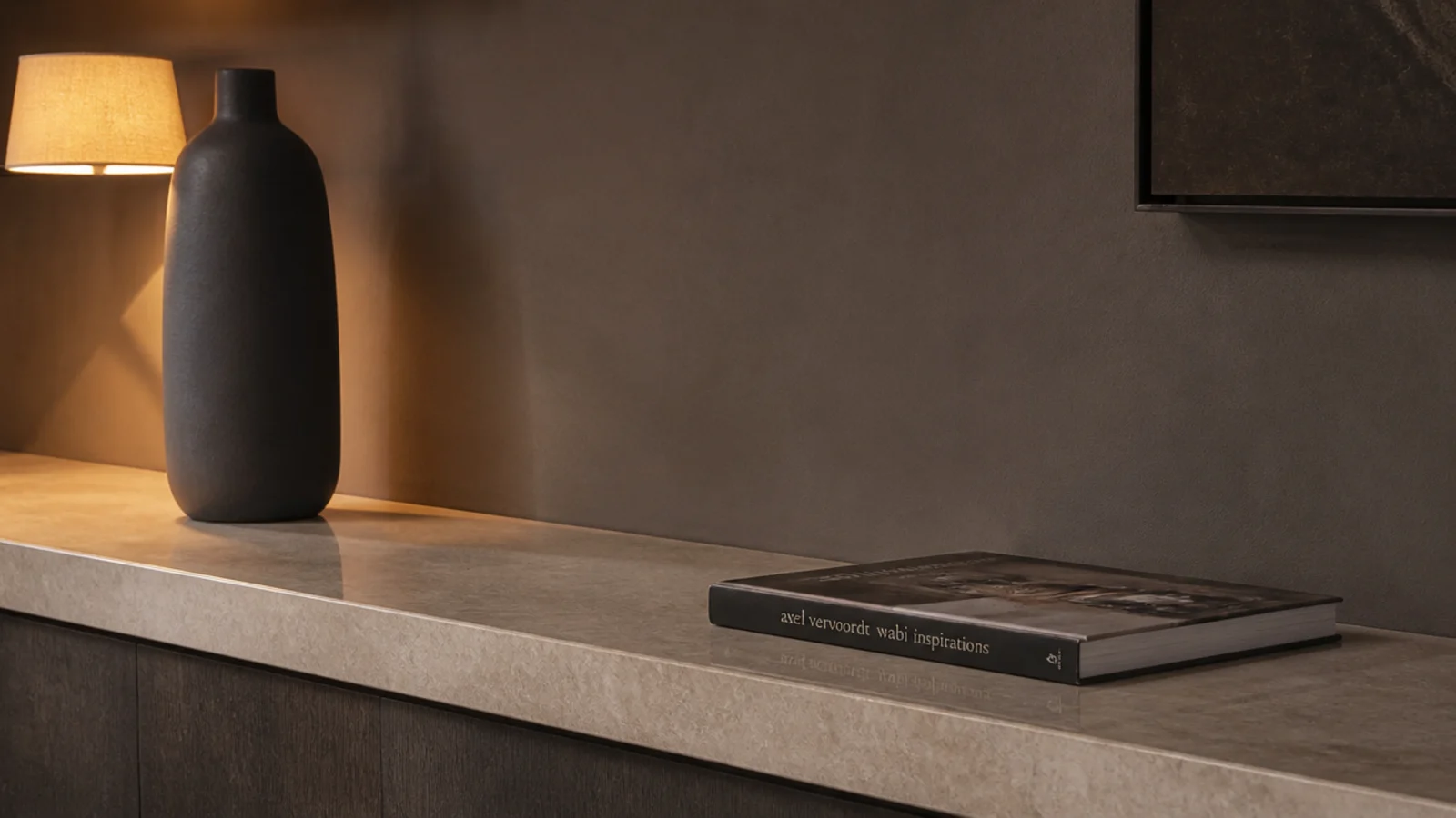 stone ledge styled with only a tall vessel and one flat book