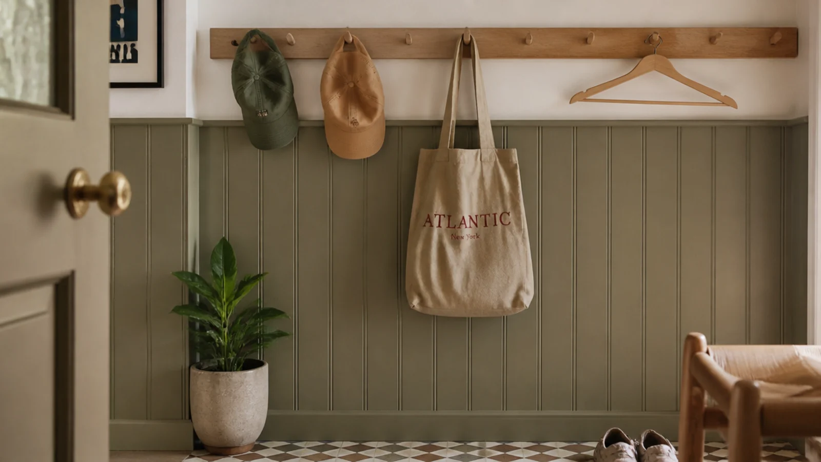 timber peg rail mounted above painted panelling holding hats and a bag