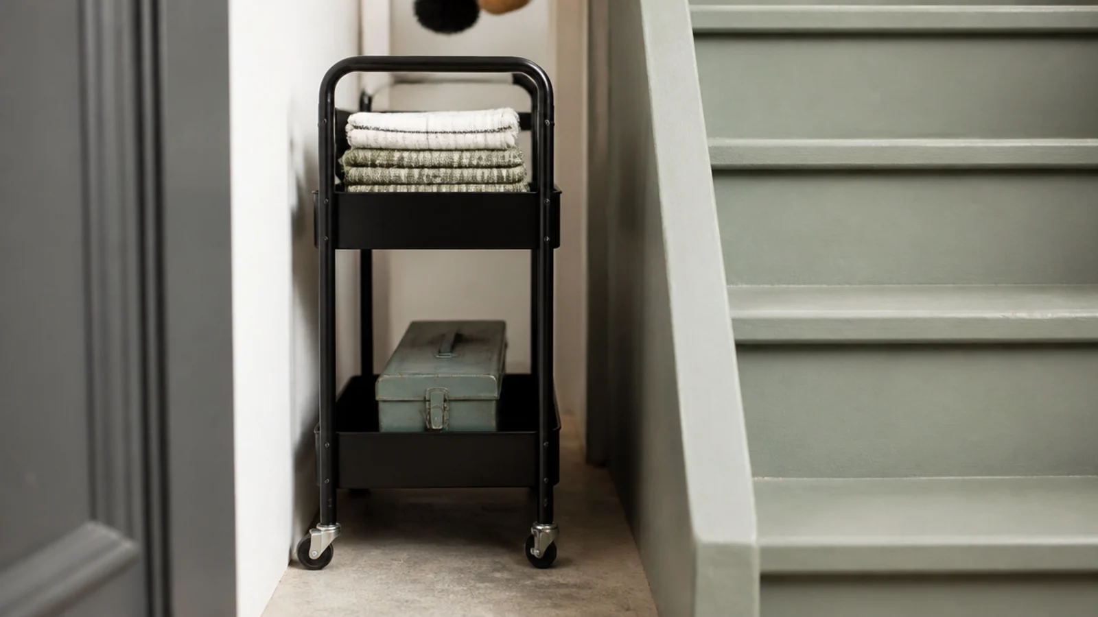 slim two tier trolley fitted into a narrow gap beside a staircase