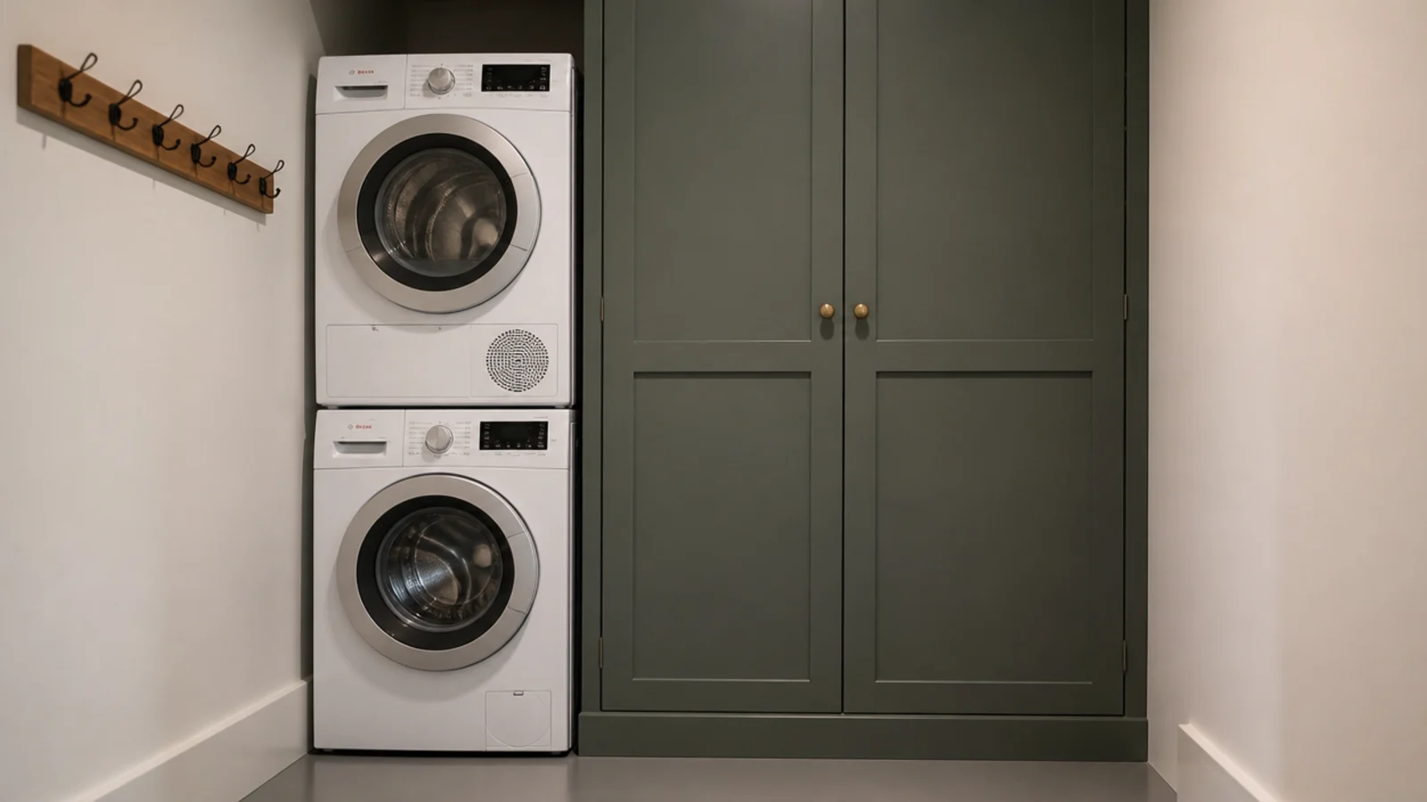 stacked machines beside a tall full height utility cupboard with doors closed