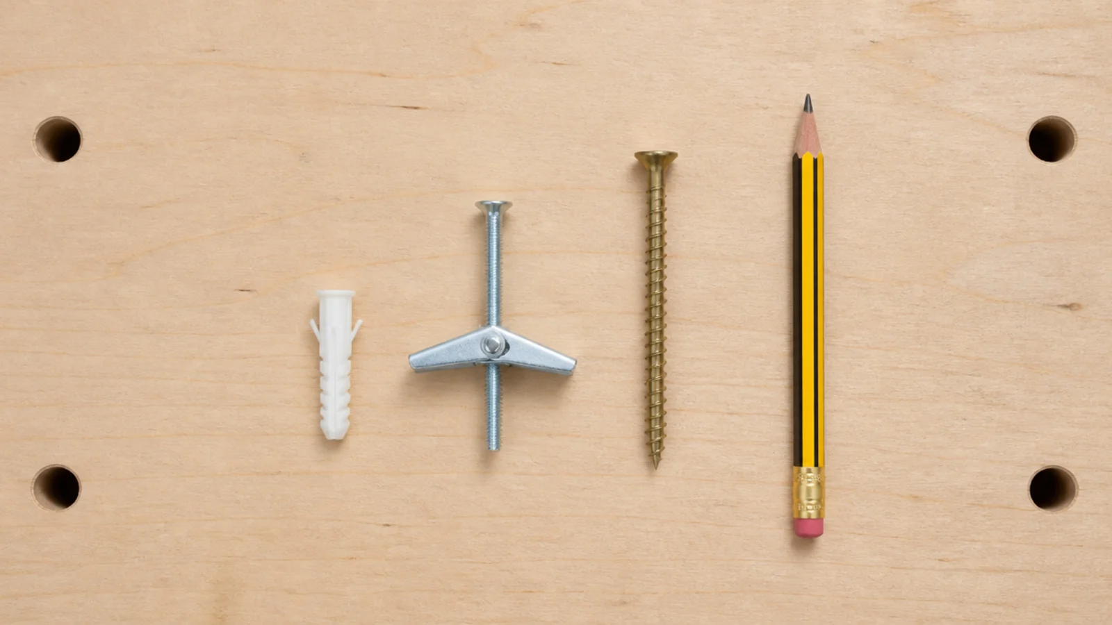plastic wall plug toggle bolt and wood screw laid out for comparison