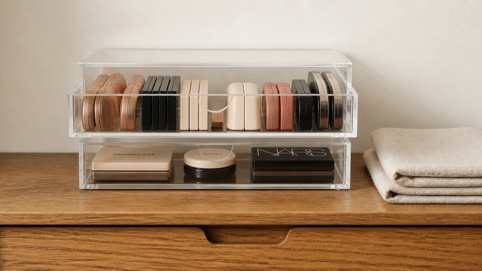 two small clear stacking drawers holding makeup on a narrow vanity