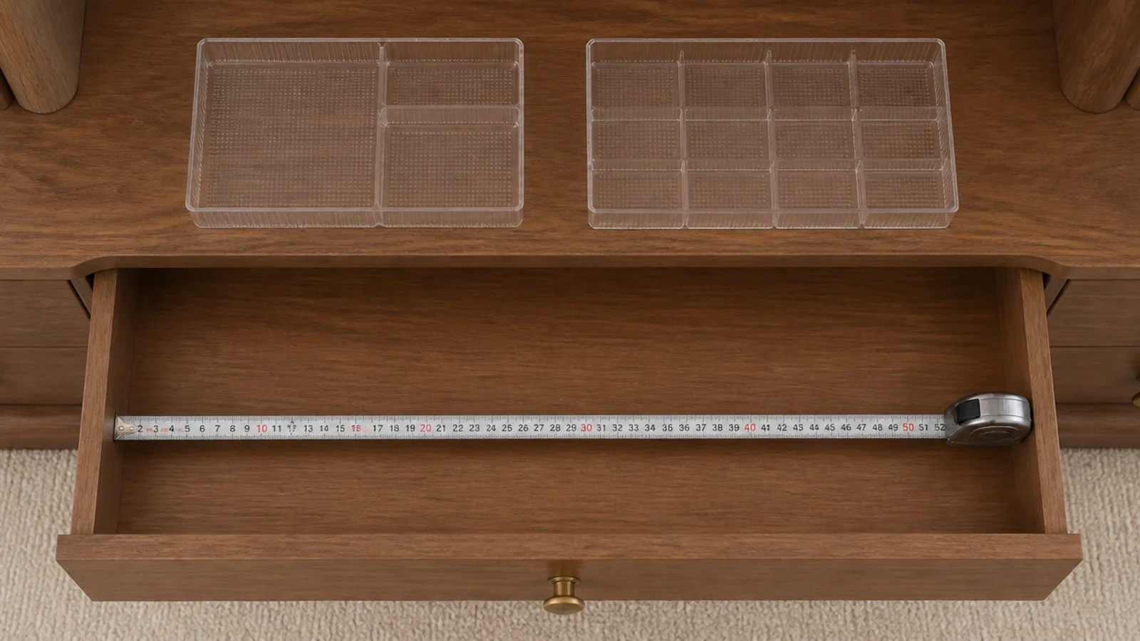 tape measure inside an open vanity drawer next to clear insert trays