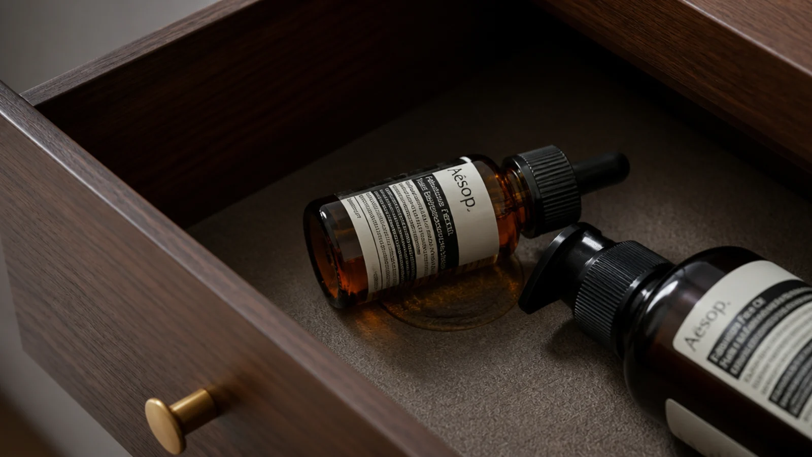 serum dropper lying flat in a drawer with a small oily leak beneath