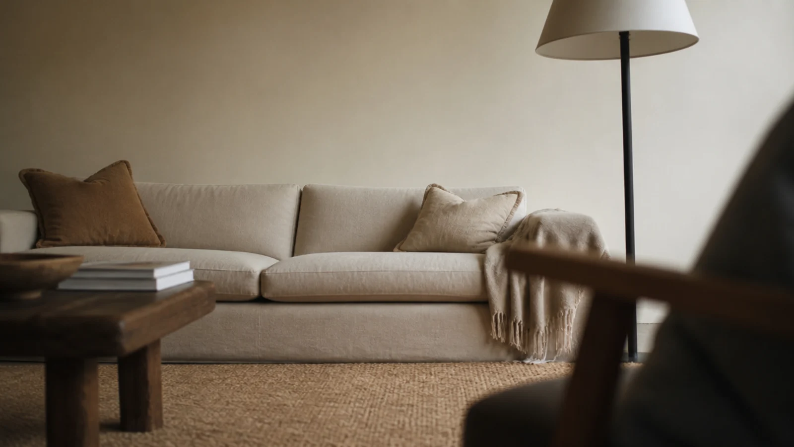 view of a bare sofa wall taken from a low armchair opposite