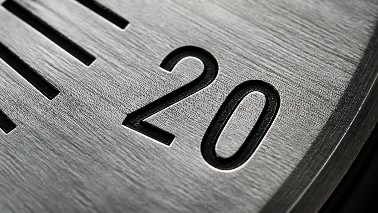 engraved numerals cut into a metal dial with filled black paint